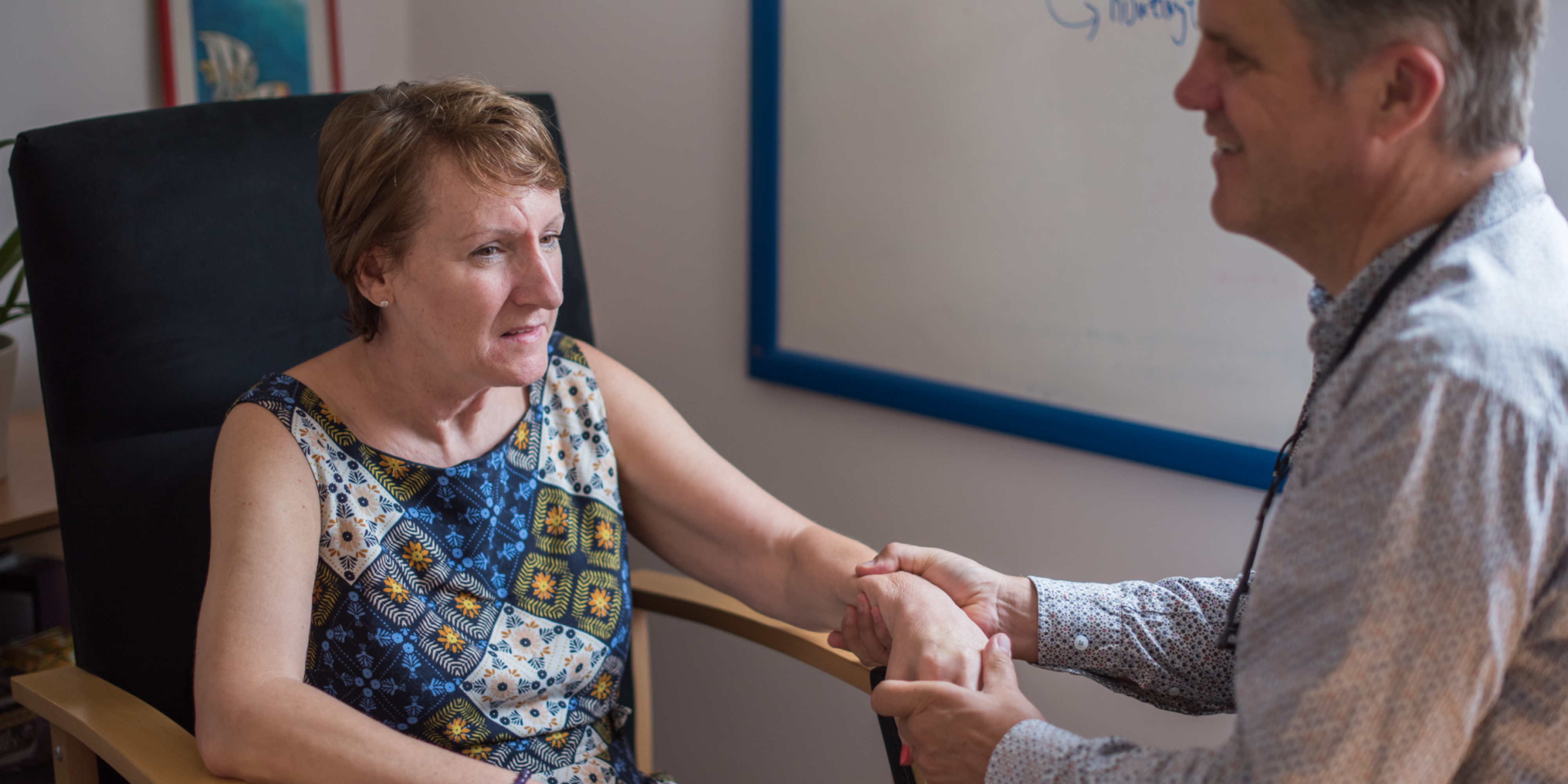 Healthcare professional offering support to a patient with Huntington's disease