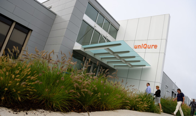 This is a picture of uniQure building with the sign visible and people walking up to the entrance