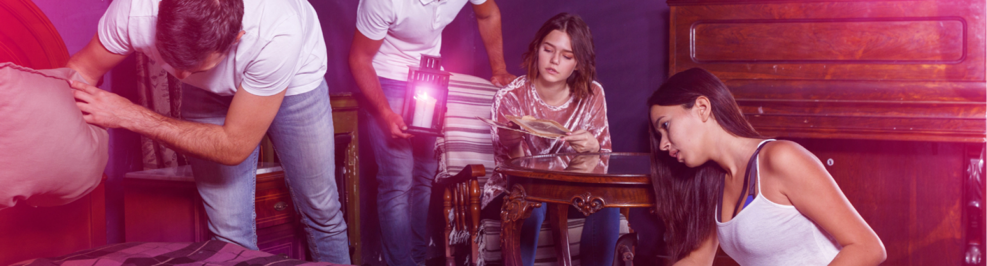 Four people looking for clues in an escape room