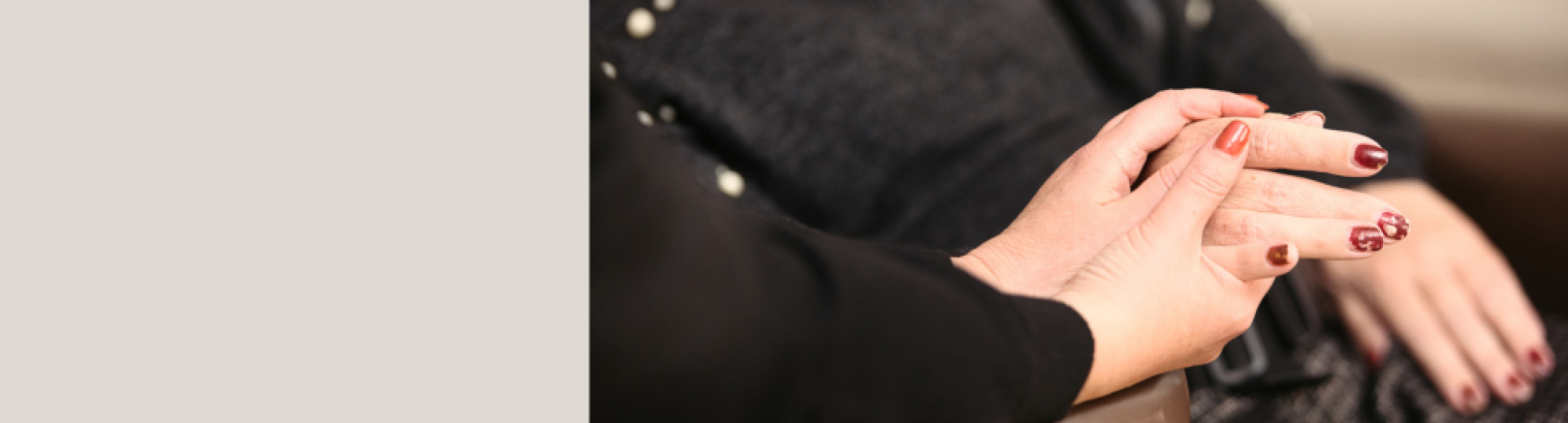 One hand being hedl by a pair of hands in a caring manner