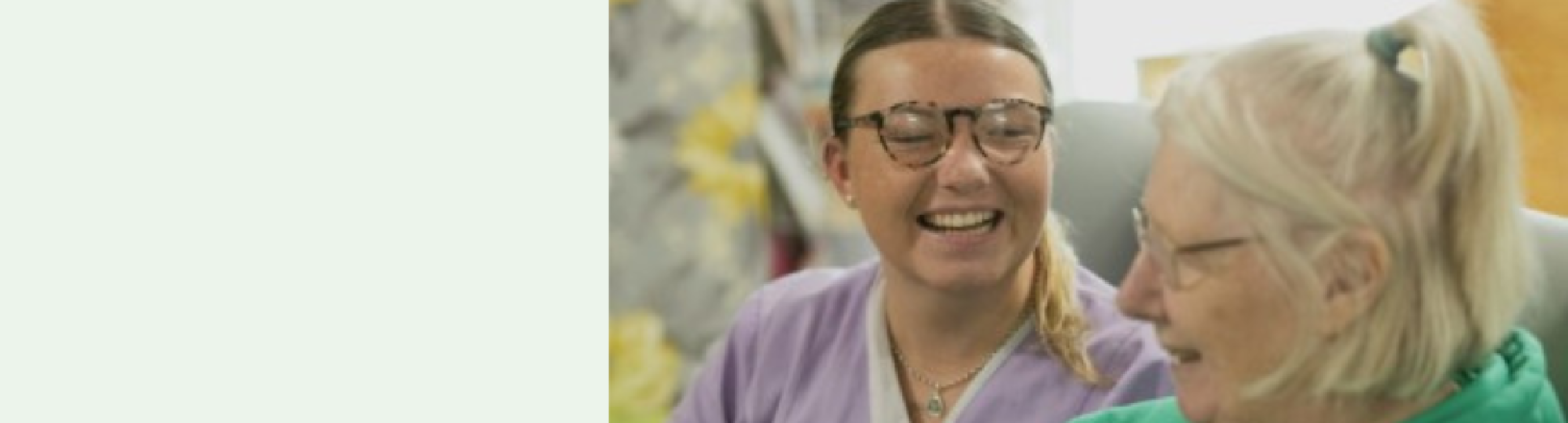 Image of two women, one younger and one older looking at each other to represent a carer with a lady